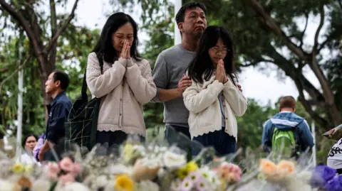 Tragedy in Hong Kong: Fire Claims 146 Lives, Thousands Mourn